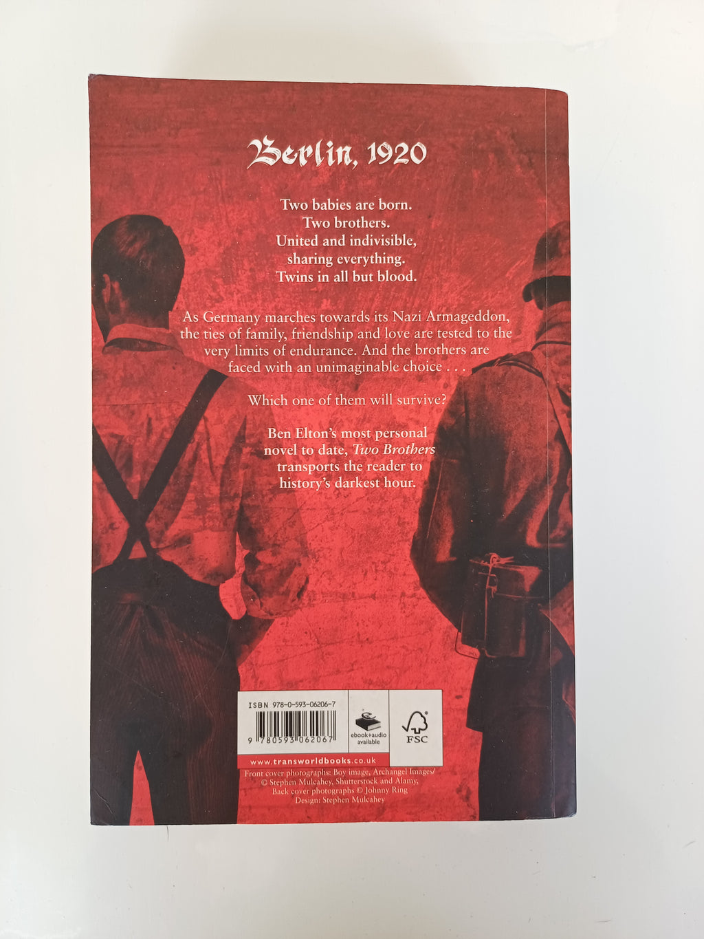 Book back cover with a red background and silhouette design on a white surface