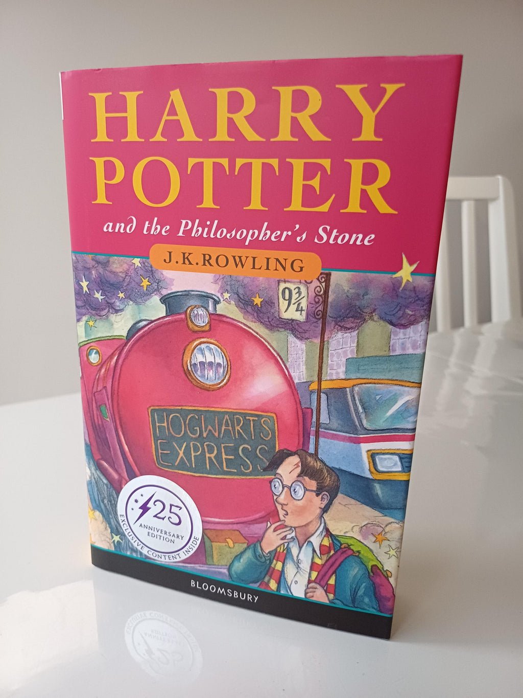 Harry Potter book cover with Hogwarts Express on a white surface