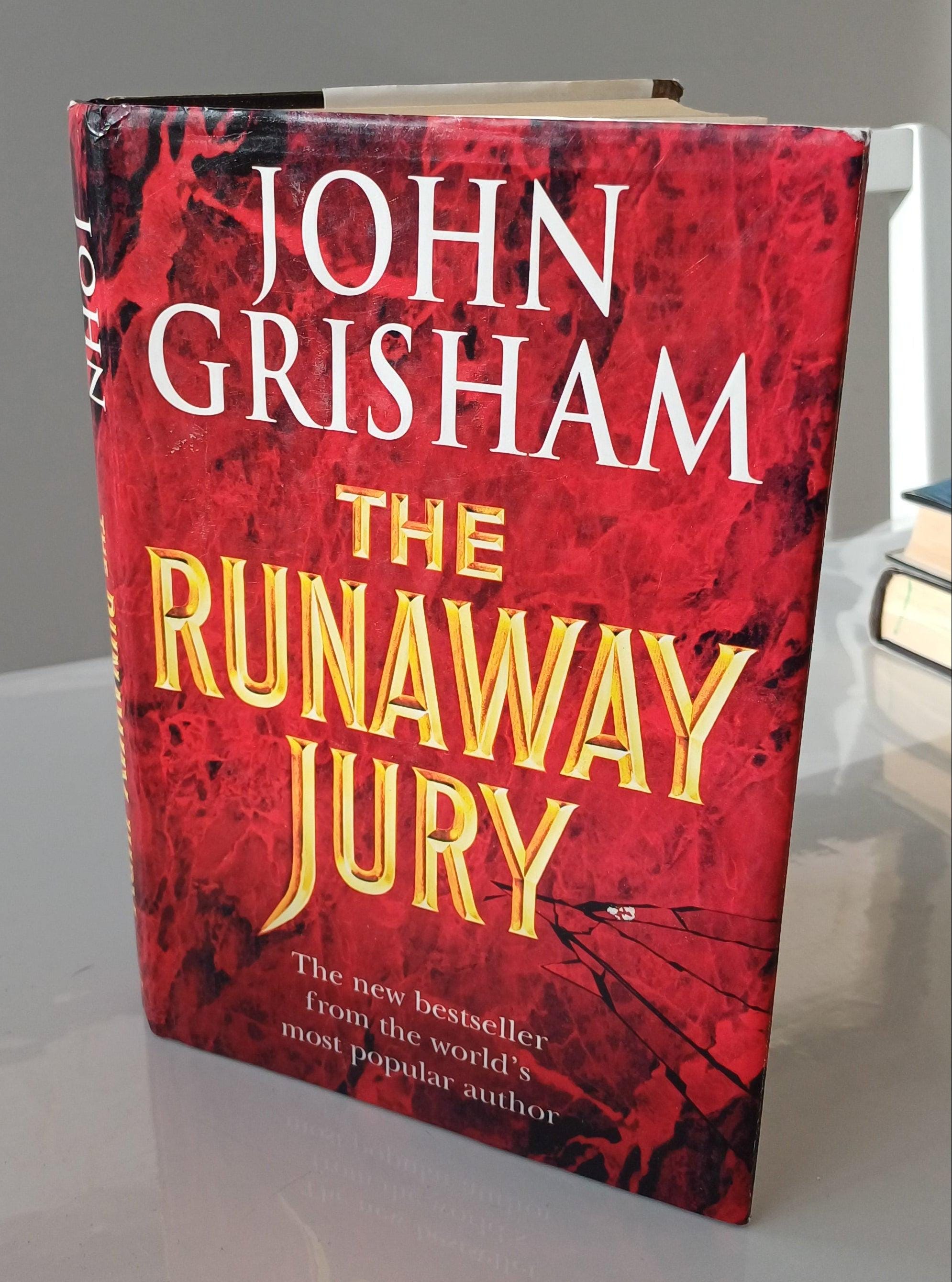 Book titled 'The Runaway Jury' by John Grisham with a red and black cover.