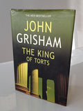 Book titled 'The King of Torts' by John Grisham on a white surface