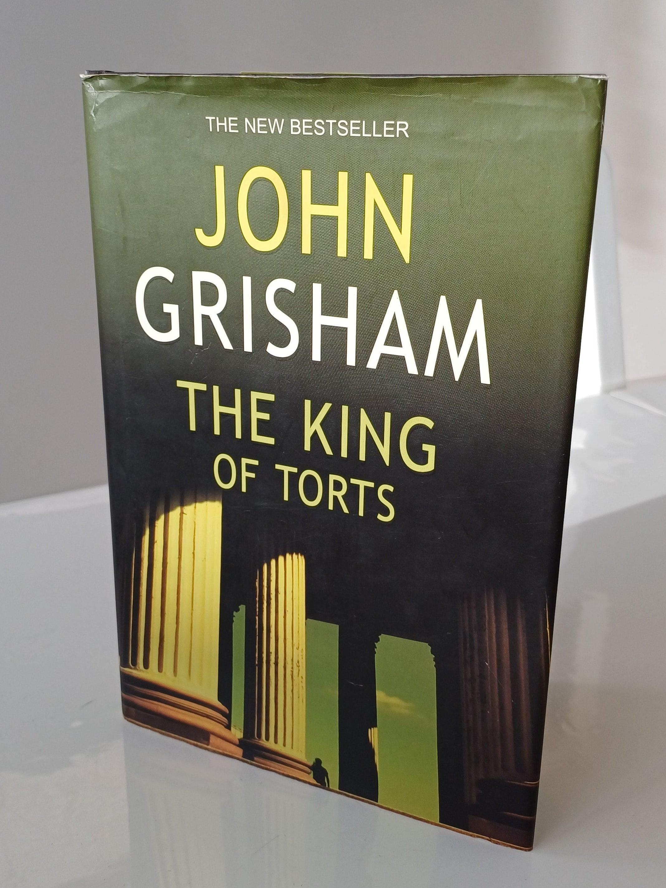 Book titled 'The King of Torts' by John Grisham on a white surface