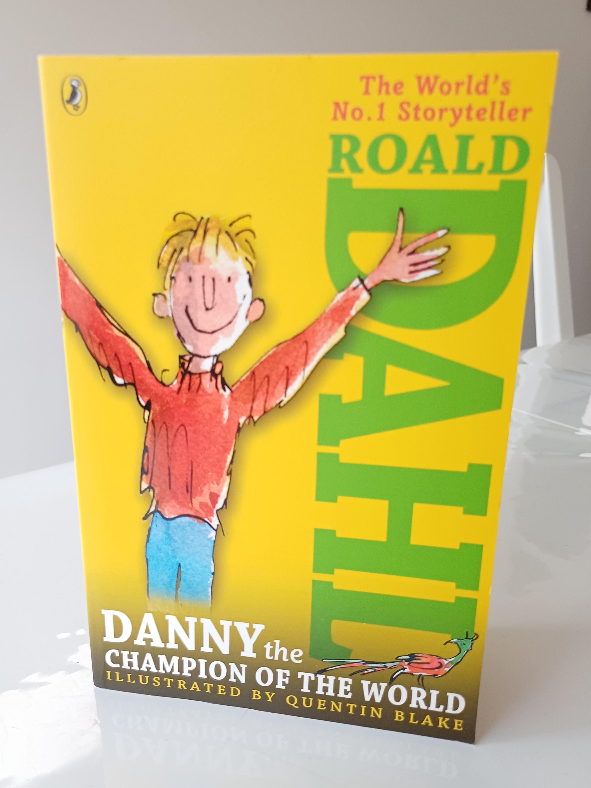 Book cover of 'Danny the Champion of the World' by Roald Dahl with a yellow background and illustration of a boy.